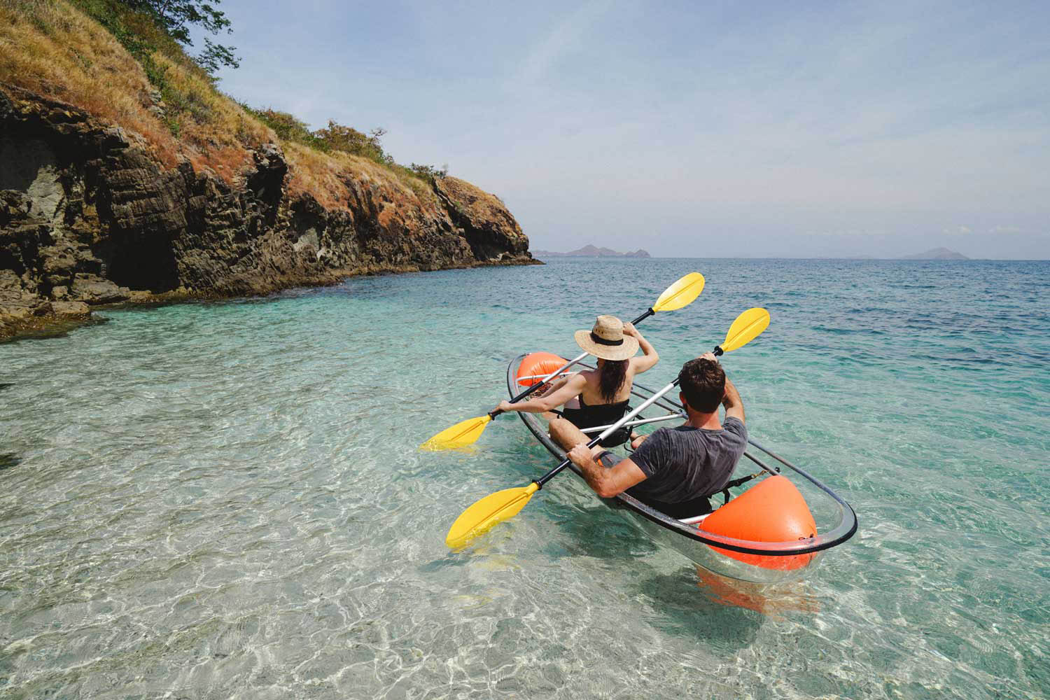 Couple kayaking in clear tropical waters near Komodo, Indonesia on a Kudanil Explorer luxury yacht expedition